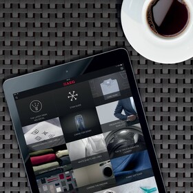 Muškarac podešava temperaturu pećnice na paru na njegovom pametnom telefonu koristeći AEG aplikaciju