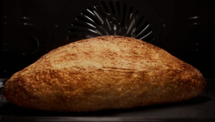 A bread being baked in the oven with steam.