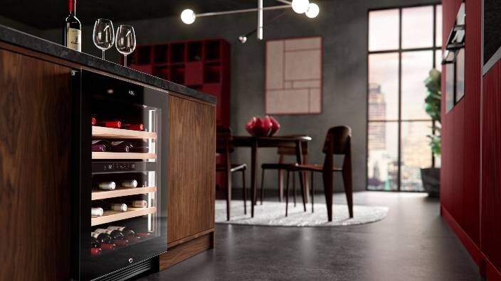 Pogled na kuhinju s hladnjakom za vino pričvršćenim za kuhinjski stol i s čašama na stolu